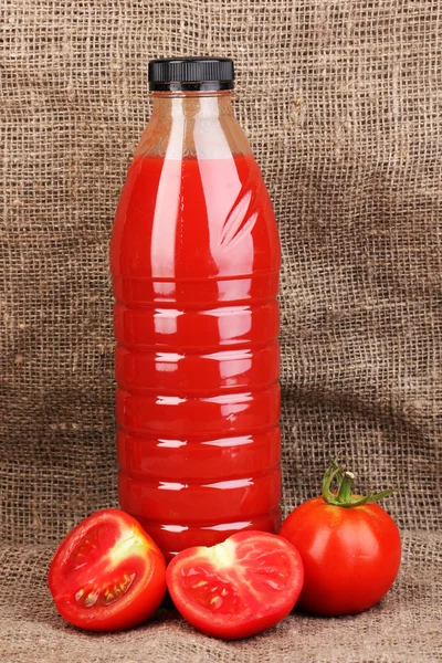 Ντομάτα χυμό σε μπουκάλι σε λινάτσα φόντο — Φωτογραφία Αρχείου