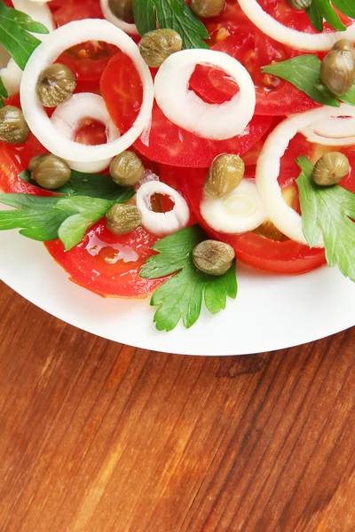 Salad with capers in the plate on wooden background close-up — Stock Photo, Image