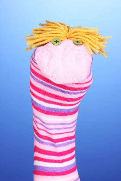 Cute sock puppet on blue background — Stock Photo, Image