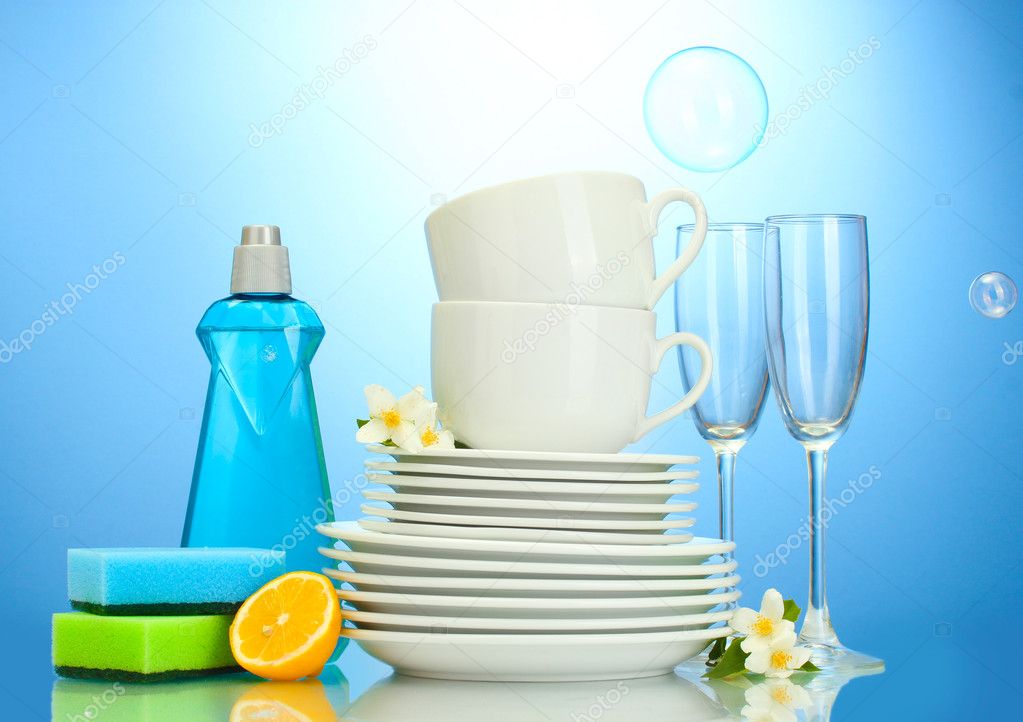 Empty clean plates, glasses and cups with dishwashing liquid, sponges