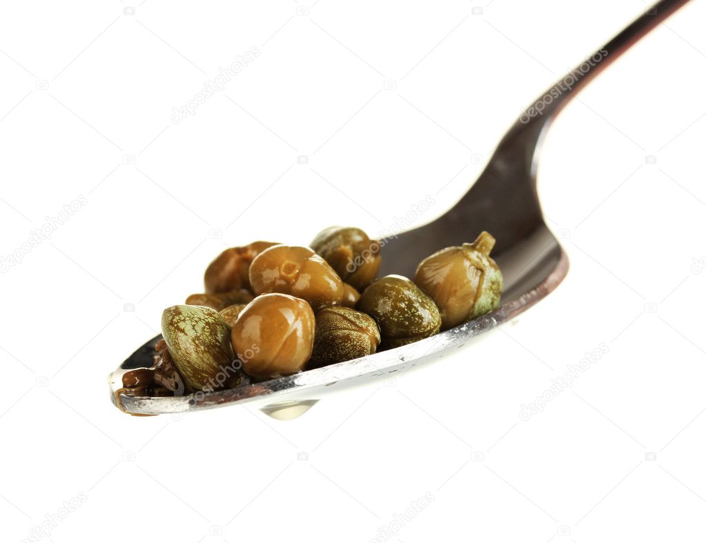 Green capers in metal spoon on white background close-up