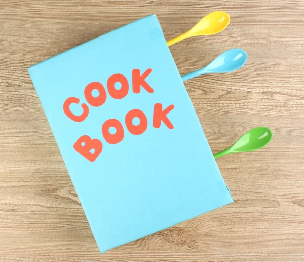 Libro de cocina y utensilios de cocina sobre fondo de madera —  Fotos de Stock