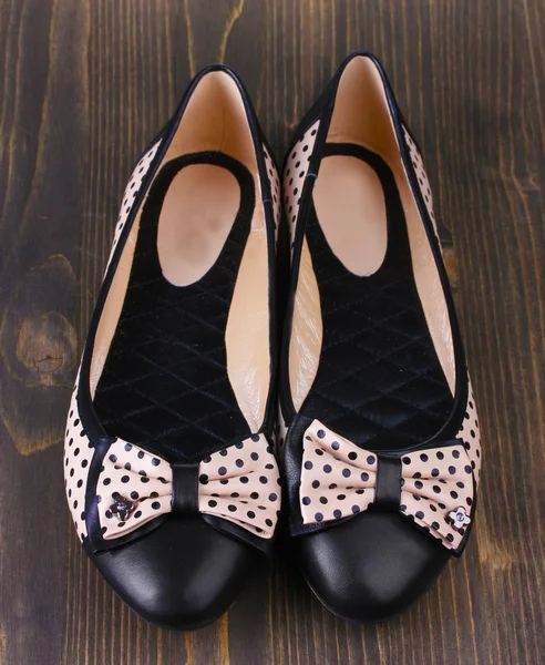 Ahşap arka plan üzerinde siyah polka noktalı desenli kadın düz bale ayakkabıları — Stok fotoğraf