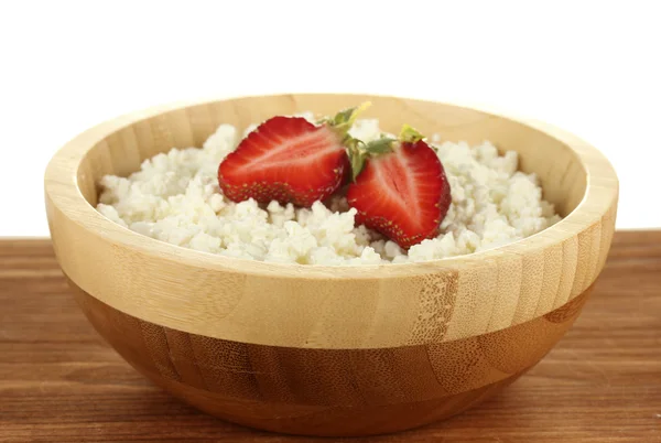 Cottage cheese with strawberry in wooden bowl on wooden table on white background close-up — Stock Photo, Image
