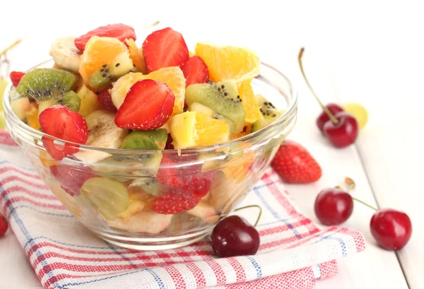Glazen kom met verse salade fruit en bessen op witte houten tafel — Stockfoto