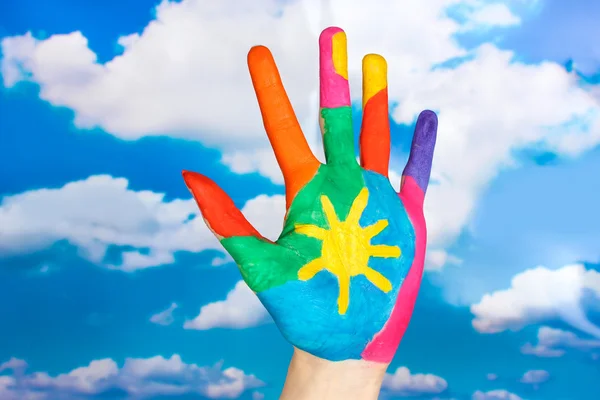 Brightly colored hand on sky background close-up — Stock Photo, Image