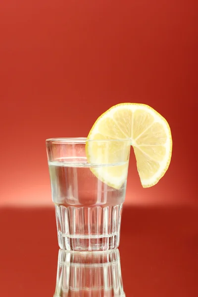 Schot van tequila op rode achtergrond close-up — Stockfoto