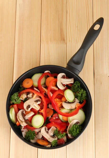 木製の背景に野菜とフライパン — ストック写真