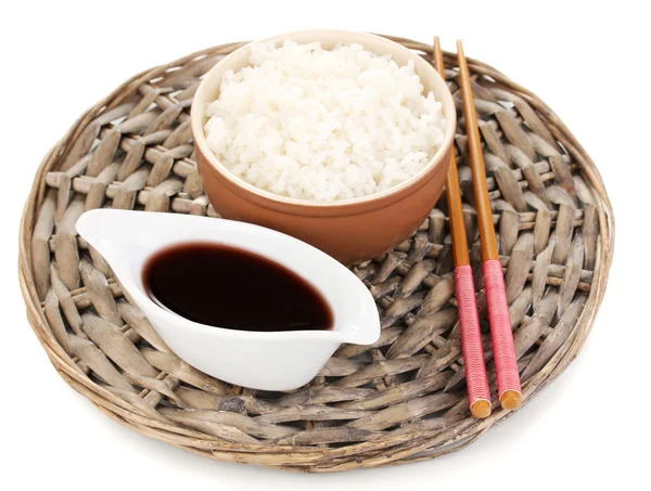 Ciotola di riso e bacchette su stuoia di vimini isoalted su bianco — Foto Stock