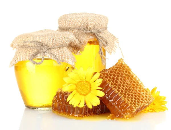 Sweet honeycombs, jars with honey and flowers, isolated on white — Stok fotoğraf