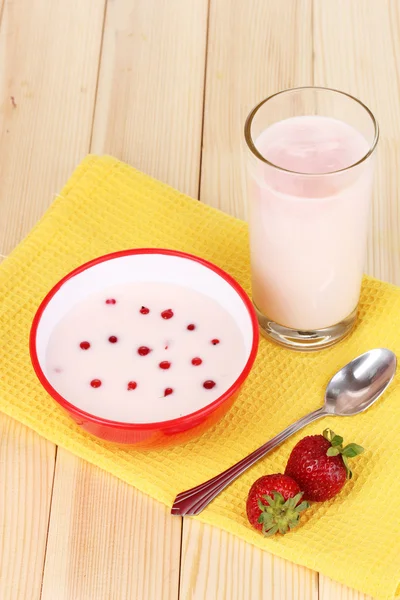 Yogurt with redcurrant and strawberry on wooden table — Stock Photo, Image