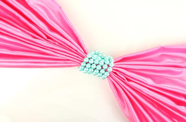 Tissu rose noué avec des perles isolées sur blanc — Photo