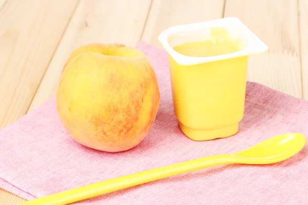 Jogurt z brzoskwini na drewnianym stole — Zdjęcie stockowe