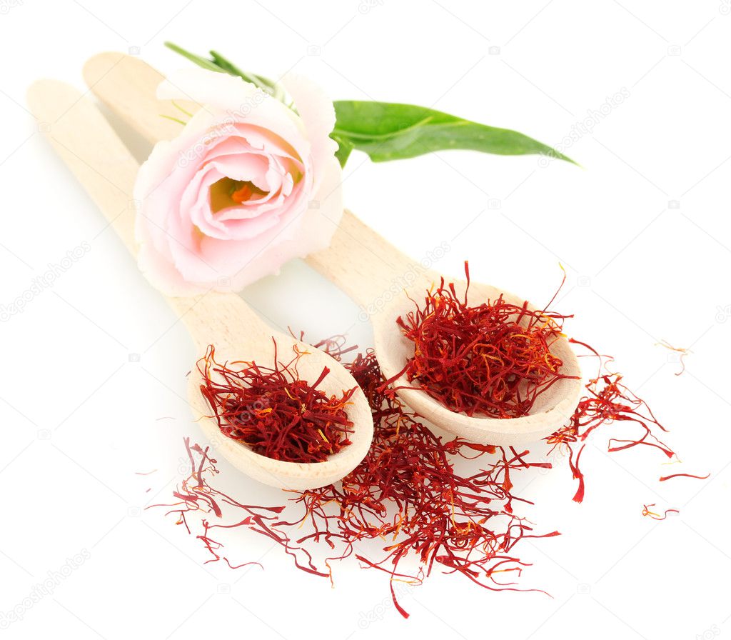 Stigmas of saffron in wooden spoons isolated on white close-up