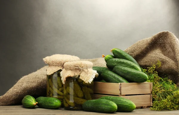 Fresh cucumbers in wooden box, pickles and dill, on grey background — Stock Photo, Image