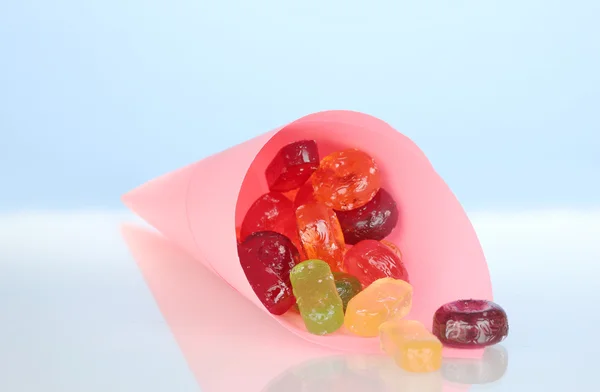 Вкусные красочные конфеты в яркой сумке на синем фоне крупным планом — стоковое фото