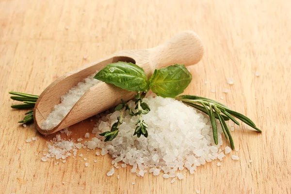 Salt in shovel with fresh basil, rosemary and thyme on wooden background — Stock Photo, Image