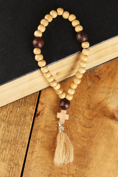 Les perles de chapelet en bois et la bible sainte sur fond en bois close-up — Photo