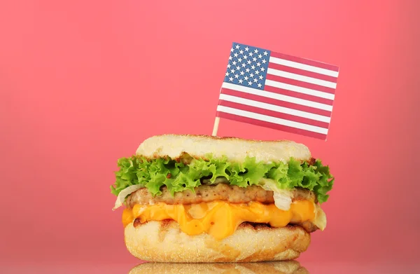 Tasty sandwich with american flag, on pink background — Stock Photo, Image