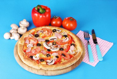 Aromatic pizza with vegetablesand mushrooms on blue background clipart