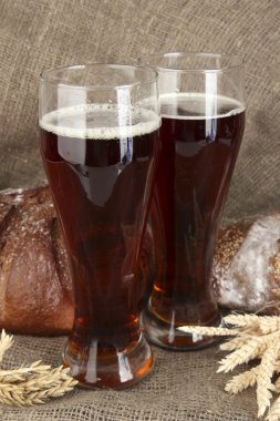 Two glasses of kvass with bread on canvas background close-up clipart