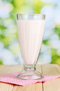 Vanilla milk shake on wooden table on bright background