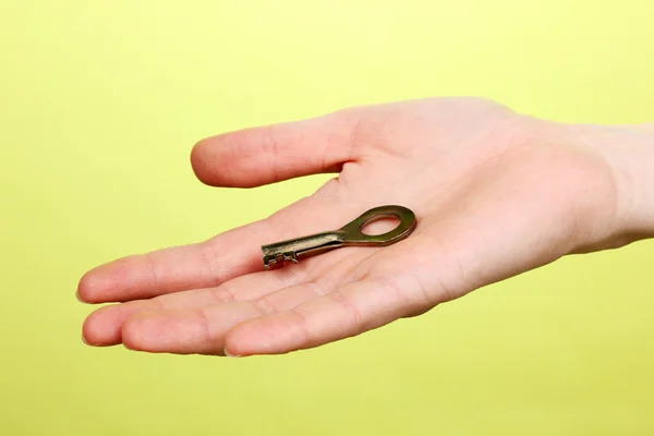 Key in hand on green background — Stock Photo, Image