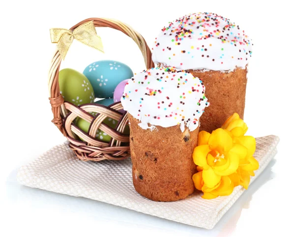 Красивые пасхальные торты, красочные яйца в корзине и цветы изолированы на белом — стоковое фото