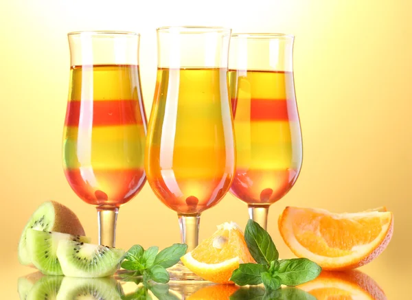 Geleia de frutas em copos e frutas no fundo amarelo — Fotografia de Stock