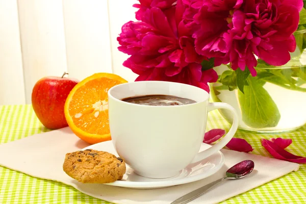 Taza de chocolate caliente, manzana, naranja, galletas y flores en la mesa en la cafetería —  Fotos de Stock