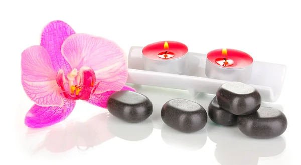 Pietre termali con fiore di orchidea e candele isolate su bianco — Foto Stock