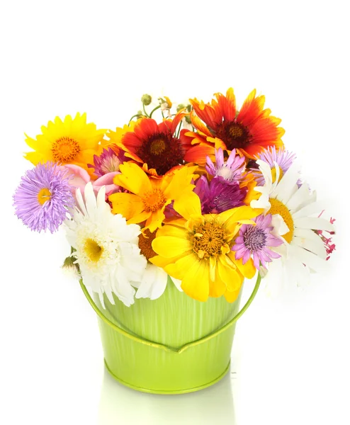 Beautiful bouquet of bright wildflowers in green metal bucket, on wooden table on blue background — Stock Photo, Image