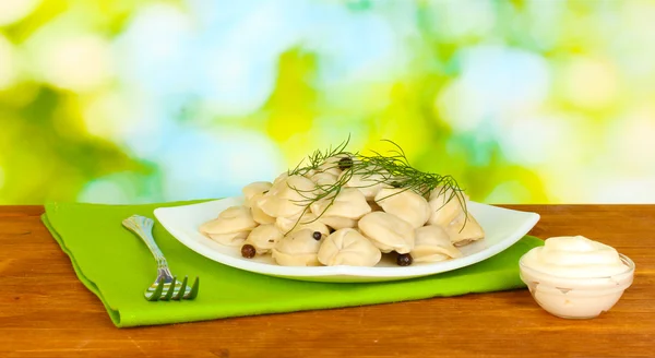 Deliciosos bolinhos cozidos no prato em fundo verde brilhante — Fotografia de Stock