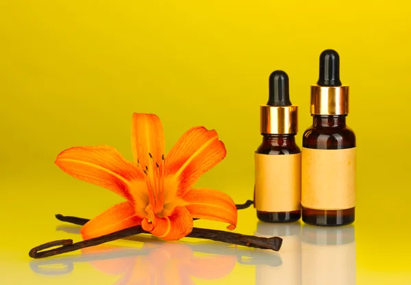 Vanilkové lusky s esenciálním olejem na barevné pozadí — Stock fotografie