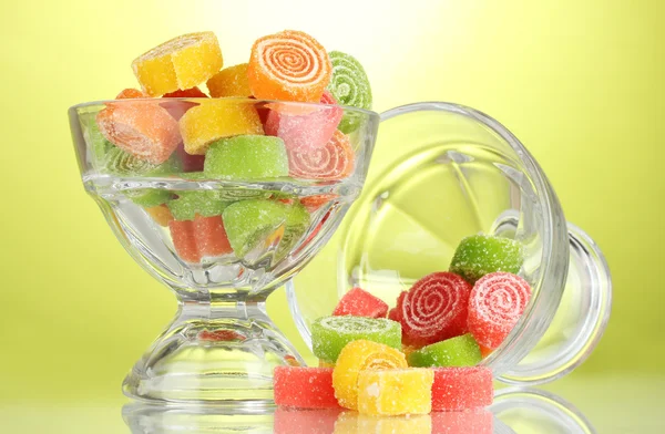 Bonbons gelée colorée dans des bols en verre sur fond vert — Photo