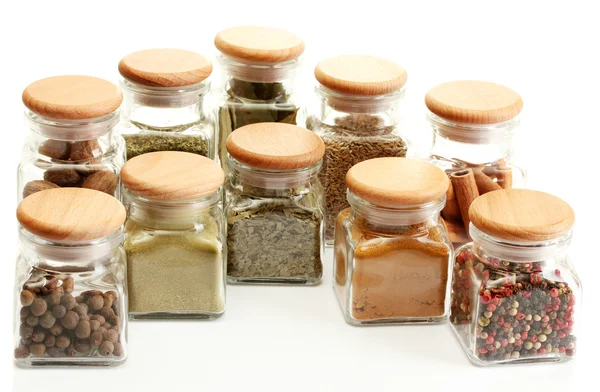 Especiarias em pó em frascos de vidro isolados em branco — Fotografia de Stock