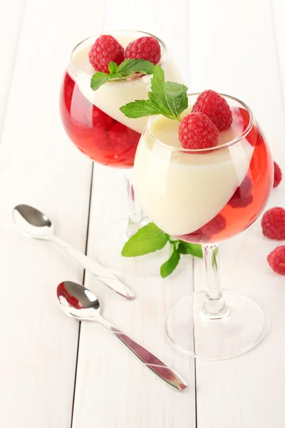 Fruit jelly with raspberries in glasses on wooden table — Stock Photo, Image