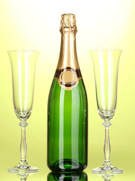 Bottle of champagne and goblets on green background — Stock Photo, Image