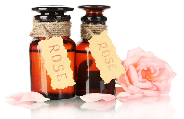 Butelki oleju i rose na białym tle — Zdjęcie stockowe