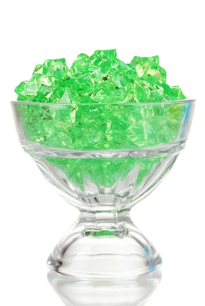 Un vetro con pietre decorative verdi isolato su bianco — Foto Stock
