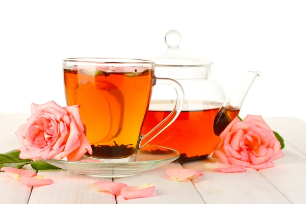 Tetera y taza de té con rosas sobre mesa de madera blanca — Foto de Stock