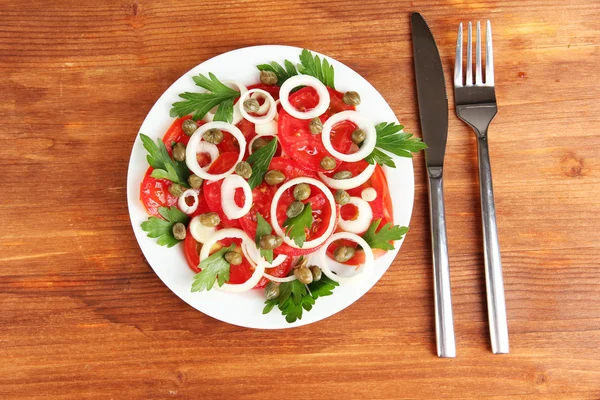 Salad with capers in the plate on wooden background — Stock Photo, Image