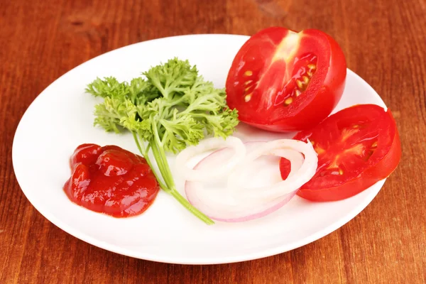 Rebanadas maduras de tomate en plato sobre mesa de madera — Foto de Stock