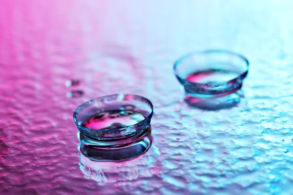 Kontaktlinsen, auf rosa-blauem Hintergrund — Stockfoto