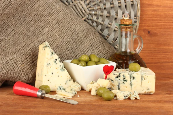 Композиция из голубого сыра и оливок в миске на деревянном фоне крупным планом — стоковое фото
