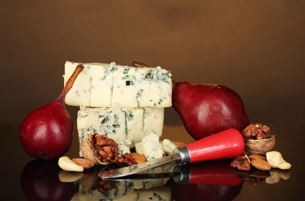 Sýry s plísní a červené hrušky s ořechy na hnědé pozadí detail — Stock fotografie