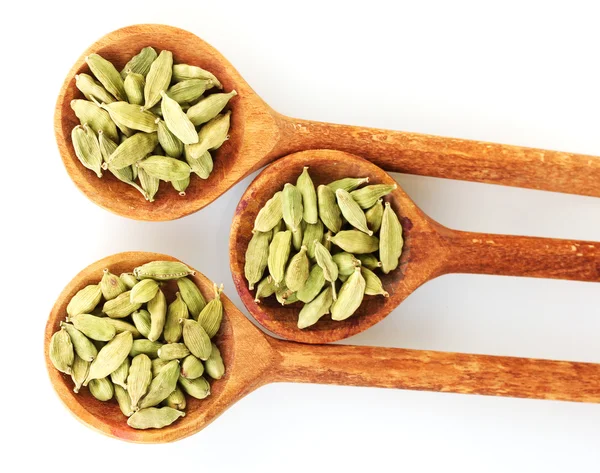 Green cardamom in wooden spoons on white background close-up — Stock Photo, Image