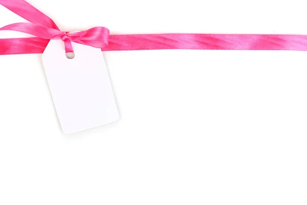 Etichetta regalo in bianco con fiocco in raso rosa e nastro isolato su bianco — Foto Stock