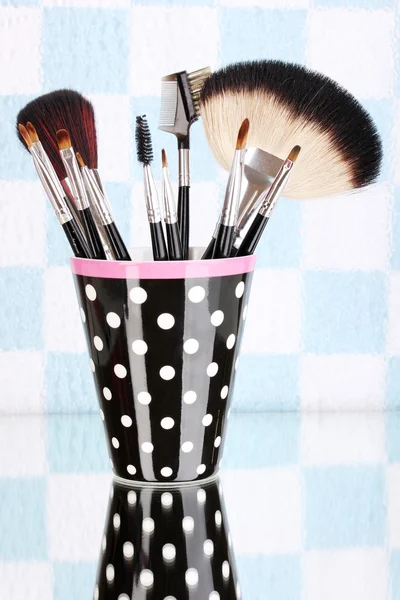 Renkli arka plan üzerinde siyah benekli Cup makyaj fırçaları — Stok fotoğraf
