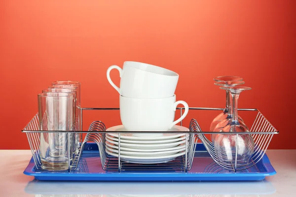 Καθαρίσει τα πιάτα σε περίπτερο σε κόκκινο φόντο — Φωτογραφία Αρχείου